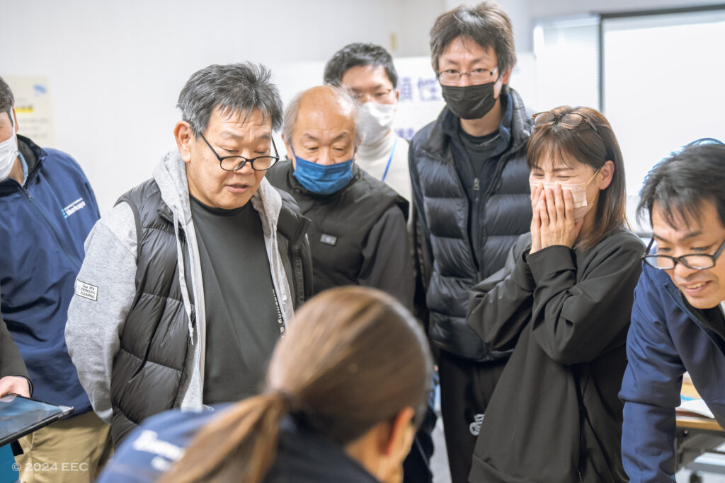 alt="メンバーでワークショップの答えを確認している様子"