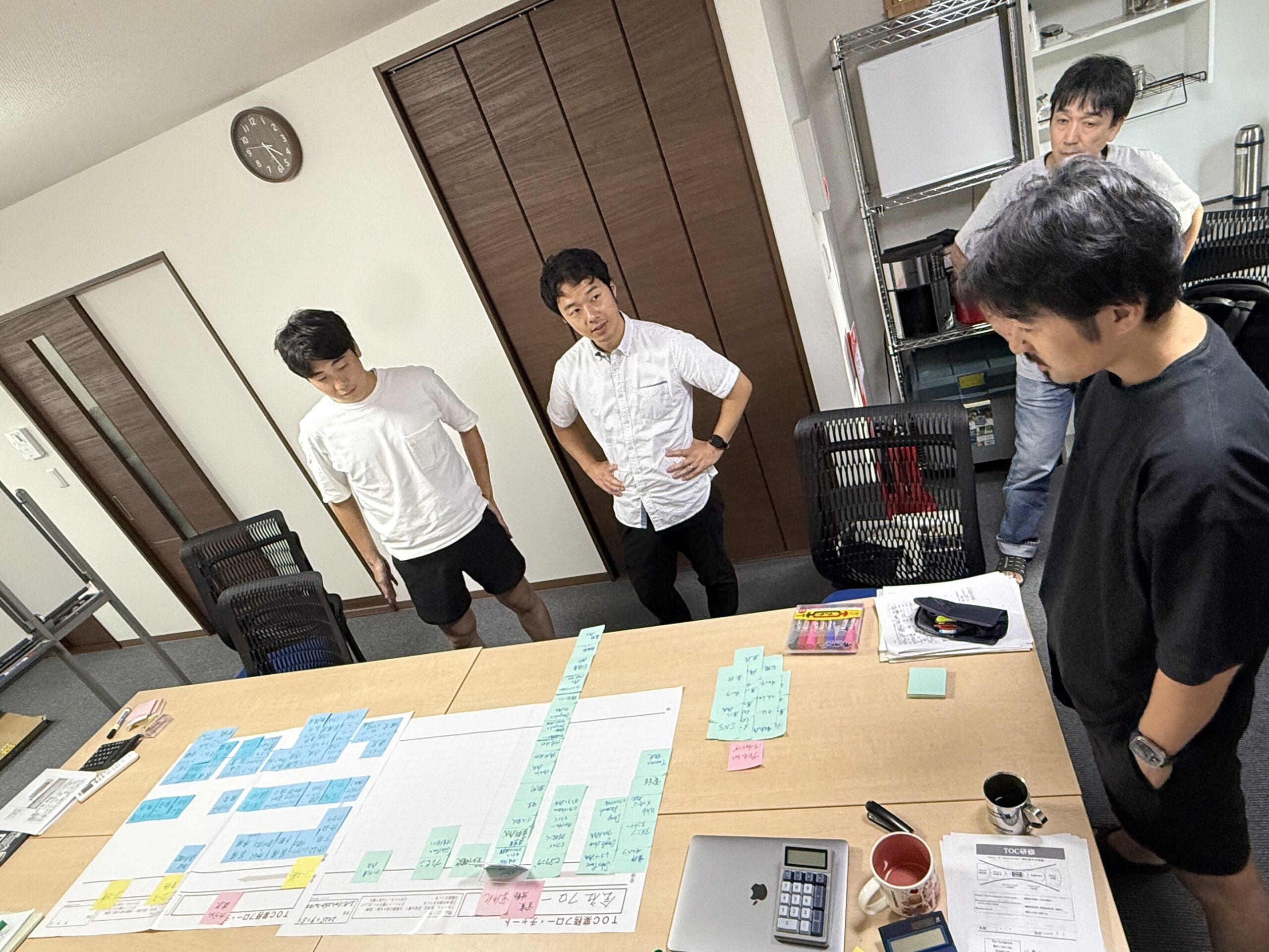 alt="エッセンシャルエデュケーションセンターのメンバーが自社のボトルネックについて議論する様子"
